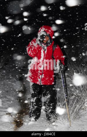 Femmina di escursionismo nel Regno Unito in una bufera di neve Foto Stock