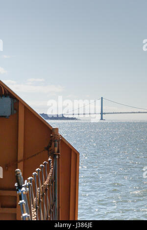 Il ponte Verrazano-Narrows è visto nella distanza dal retro dello Stato Island Ferry. Foto Stock