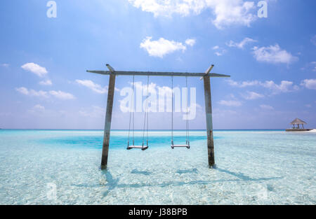 Paradiso tropicale altalene oltre cristalline acque blu turchese Foto Stock