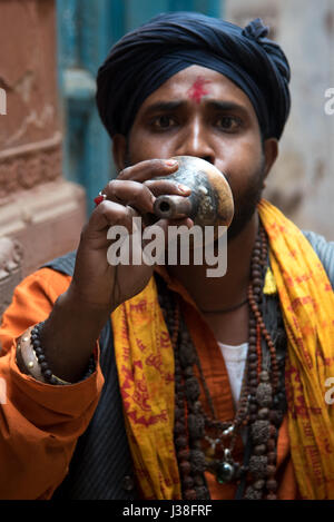 Il serpente incantatore a giocare il suo flauto di Varanasi, India Foto Stock