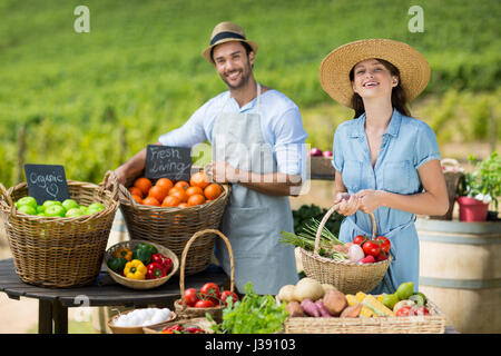 Ritratto di sorridere amici la vendita di frutta e verdura al mercato contadino Foto Stock