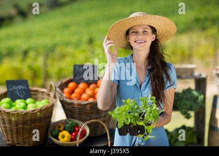 Ritratto di donna holding verdura a foglia al mercato contadino Foto Stock