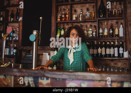 Ritratto di bellissima femmina bar gara permanente al bancone bar Foto Stock