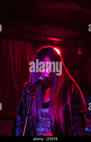 Giovane donna effettuando in corrispondenza di un club Foto Stock