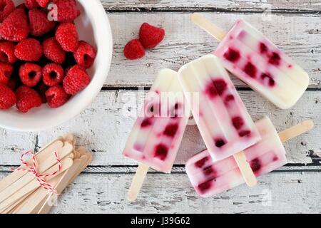 Gruppo di fatti in casa lampone vaniglia popsicles su un rustico di legno bianco sullo sfondo Foto Stock