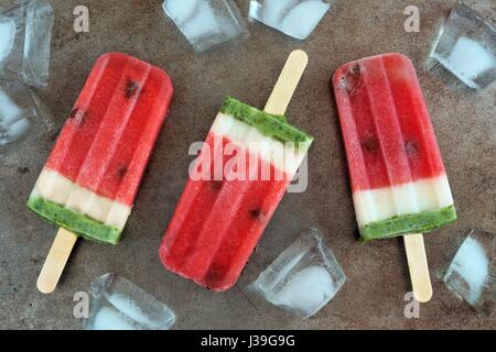 In casa di anguria popsicles con ghiaccio contro un vintage vassoio metallico sullo sfondo Foto Stock