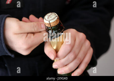 Donna apertura di una bottiglia di champagne. Foto Stock
