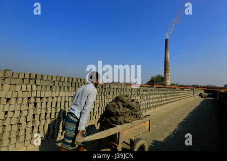 Un operaio porta fango su un carrello di spinta a mattonaia a Amin Bazar. Dacca in Bangladesh. Foto Stock