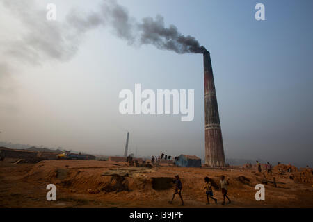 Un camino di una mattonaia emette fumo nero a Amin Bazar. Dacca in Bangladesh. Foto Stock