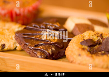 Pane appena sfornato, vaniglia e biscotti con scaglie di cioccolato sul vassoio in legno Foto Stock