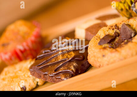 Pane appena sfornato, vaniglia e biscotti con scaglie di cioccolato sul vassoio in legno Foto Stock