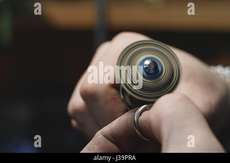 Close-up del processo di lucidatura di Anello in oro bianco in un workshop di gioielli. Foto Stock