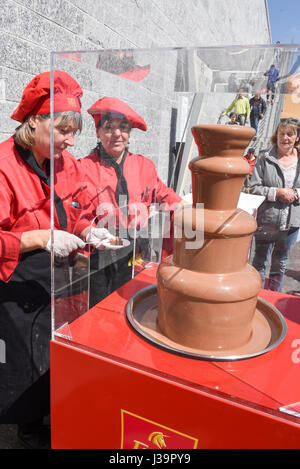 Il Monte Generoso, Svizzera -8 aprile 2017: Ladies che preparare gli spiedini di frutta con una fontana di cioccolato per i loro clienti sul Monte Generoso su SVIZZ Foto Stock