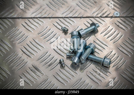 Le viti di acciaio sulla piastra di metallo, close up Foto Stock
