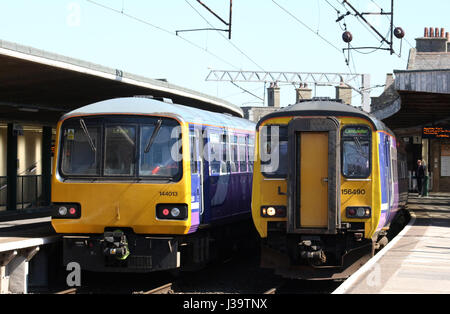 Due diesel multiple unit treni gestiti da arrivano treni nord in piattaforme 1 e 2 a Carnforth. Classe 144 Pacer e classe 156 Super Sprinter. Foto Stock