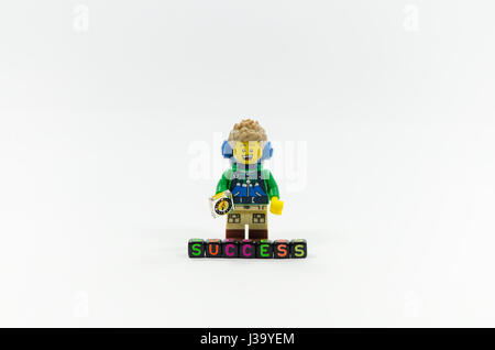 Lego escursionista miniatura in piedi dietro il successo di parola magia con alfabeto colorato perle. Foto Stock
