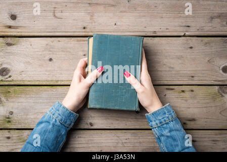 Donna di mani prenota su un tavolo di legno Foto Stock