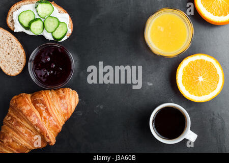 Pane tostato, croissant, succo d'arancia e caffè rustico tavolo blu, brunch tabella visto dal di sopra Foto Stock