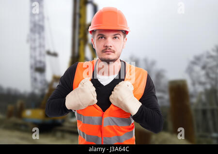 Bello architetto in uniforme di protezione agendo come supereroe all'aperto Foto Stock