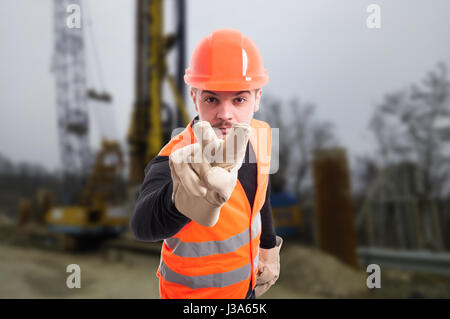 Attraente builder facendo sto guardando la gesto come concetto di intimidazione sul sito in costruzione Foto Stock