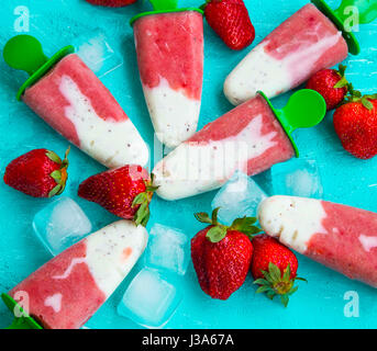 La fragola e popsicles yogurt con frutta in estate blu, sfondo gustosi dessert ghiacciato Foto Stock