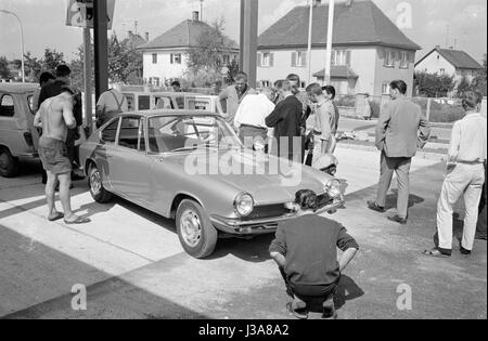 I clienti di un distributore di benzina Agip guardando una nuova vettura, 1963 Foto Stock