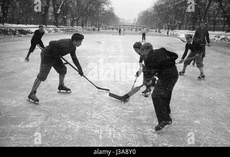 Bambini che giocano hockey su ghiaccio sulla congelati Nymphenburg Canal, 1954 Foto Stock