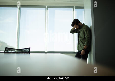 Premuto imprenditore in piedi dalla finestra di office Foto Stock