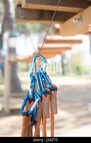 Molti moschettone blu garanzia di sicurezza pronto per l'uso, parco giochi avventura il percorso al di fuori della messa a fuoco in background Foto Stock