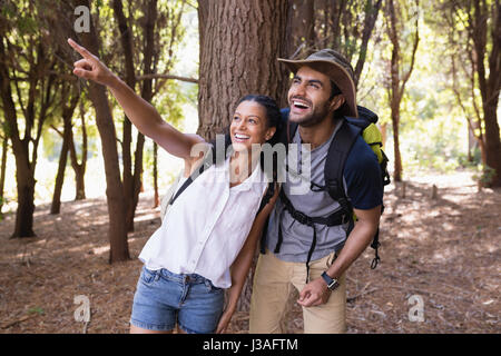 Donna felice rivolto all uomo nella foresta durante le escursioni Foto Stock