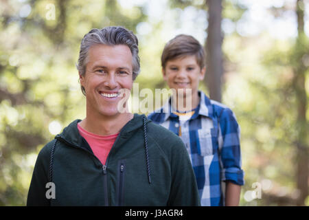 Ritratto di felice padre e figlio escursioni nella foresta Foto Stock