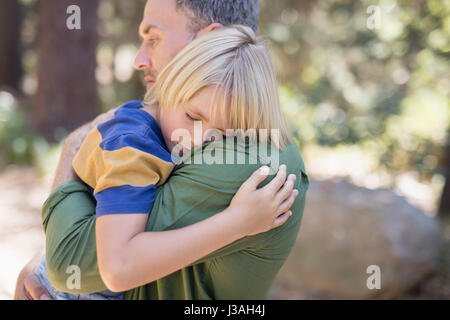 Chiusura del figlio di dormire sulla spalla dei padri nella foresta Foto Stock