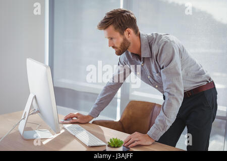 Attento lavoro esecutivo su personal computer presso la scrivania in ufficio Foto Stock