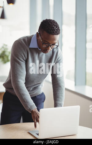 Esecutivo attento utilizzando laptop alla scrivania in ufficio Foto Stock