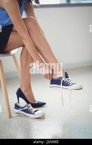 Sezione bassa della donna che indossa scarpe di tela in office Foto Stock