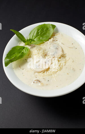 Minestra di crema con pollo e funghi. Stile italiano. Il cibo italiano. Cucina Italiana. Studio shot sul buio o sfondo nero. Foto Stock