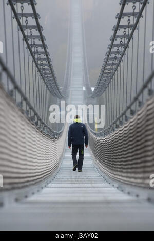 Diga Rappbode, Germania. Il 4 maggio 2017. Un dipendente Harzdrenalin passeggiate attraverso un pedone ponte di sospensione da parte della società Harzdrenalin nella fitta nebbia, presso la diga Rappbode, Germania, 4 maggio 2017. Il ponte è prevista per il 7 maggio 2017. Credito: dpa picture alliance/Alamy Live News Foto Stock