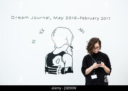 New York, US. 05 Maggio, 2017. New York, NY - 5 maggio 2017. Il giorno di apertura del fregio Art Fair, presentazione di arte moderna e contemporanea presentata da gallerie provenienti da tutto il mondo, su Randall's Island in New York City. Una donna si erge accanto al cartello del fregio progetto 'Dream ufficiale,' un video da Giovanni Rafman. Credit: Ed Lefkowicz/Alamy Live News Foto Stock