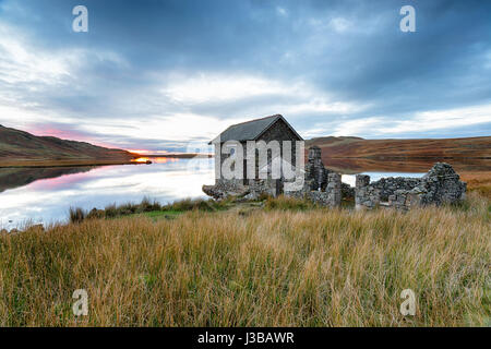I ruderi di una vecchia casa in barca sulle rive del Devoke acqua nel Parco nazionale del Lake District in Cumbria Foto Stock