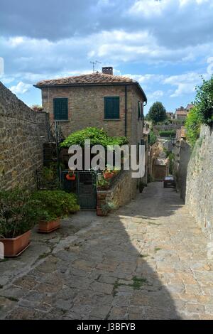 Vecchie case storiche in stradina nel centro storico della città di Volterra, Italia Foto Stock