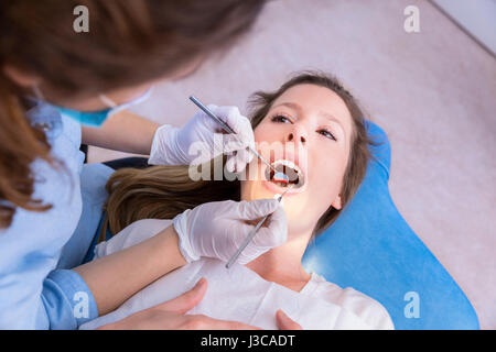 Dentista donna esame paziente Foto Stock