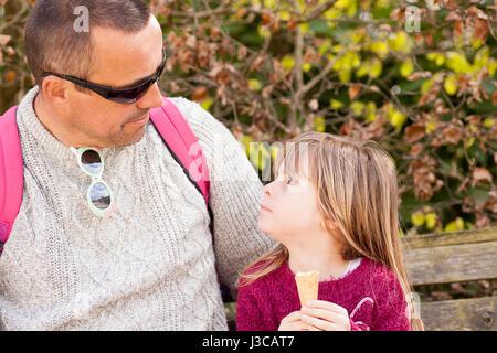 La gente reale. L uomo e la bambina guardando ogni altro. Padre e figlia godendo del tempo di qualità all'aperto con gelato. Candide ritratto di famiglia. Foto Stock