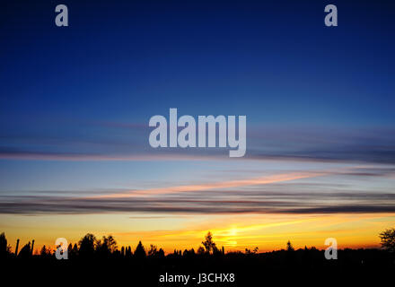 Silhoutte di albero e isole al lontano con colori vividi del cielo durante il tramonto a Kota Kinabalu, Foto Stock