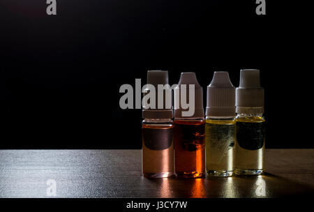Vape isolato e liquido per sigaretta elettronica su uno sfondo scuro. Foto Stock