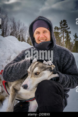 Uomo con Husky, uno sled dog, Lapponia svedese, Svezia Foto Stock