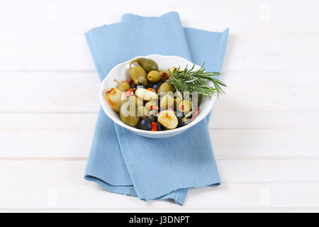 Ciotola di olive in salamoia, capperi, cappero di bacche e aglio Foto Stock