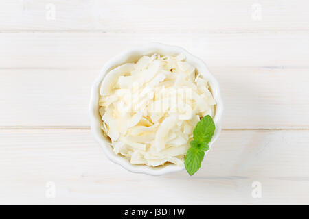 Ciotola di scaglie di cocco su sfondo bianco Foto Stock