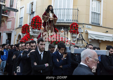 Fedeli cattolici portano la statua di El Cristo de Medinaceli (Cristo di Medinaceli) nel cerimoniale processione di strada da Saint James Church (Iglesia de Santiago Apostol) alla chiesa del Santo Cristo de la Salud a Malaga, in Andalusia in Spagna il 7 gennaio 2016, grazie alla finitura del lavori di restauro nella chiesa. Foto Stock