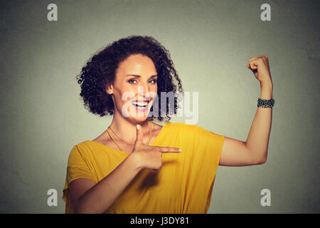 Closeup ritratto montare di mezza età modello sano donna muscoli di flessione fiduciosi che mostra la sua forza isolato su sfondo grigio. Emozione positiva faci Foto Stock