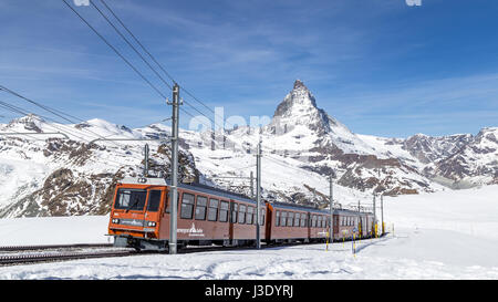 Zermatt, Svizzera - 12 Aprile 2017: il rosso Gornergrat treno di fronte nevoso Monte Cervino Foto Stock